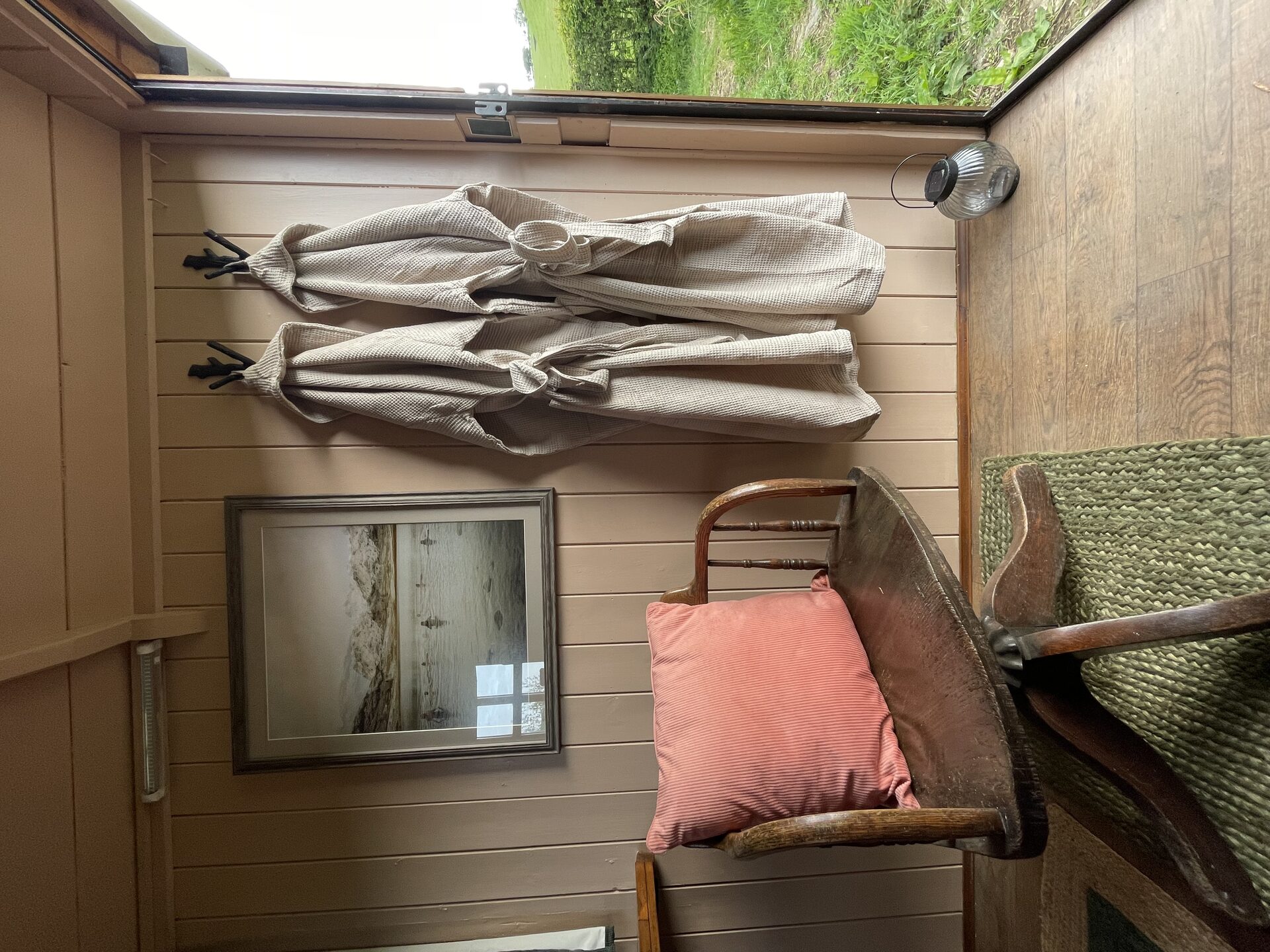 Linen robes and rustic chair inside the shepherd's hut